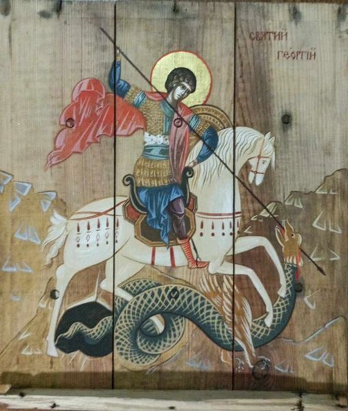 A painting of st. George on horseback with the dragon in front