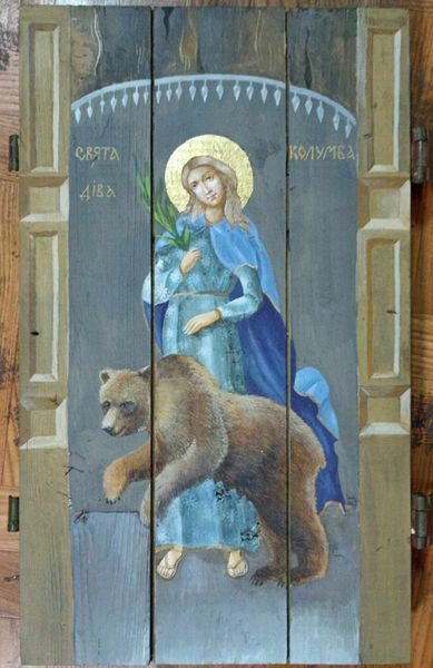 A painting of st. Catherine holding a spear and standing next to a bear