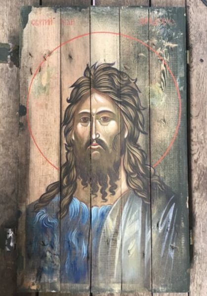 A painting of jesus is on the side of a building.