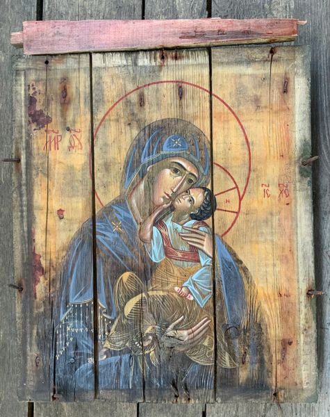 A painting of mary holding jesus on the side of a building.