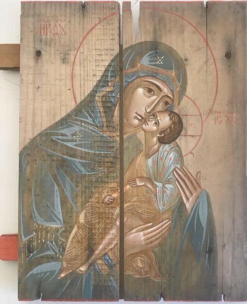 A painting of mary holding jesus on the side of a building.
