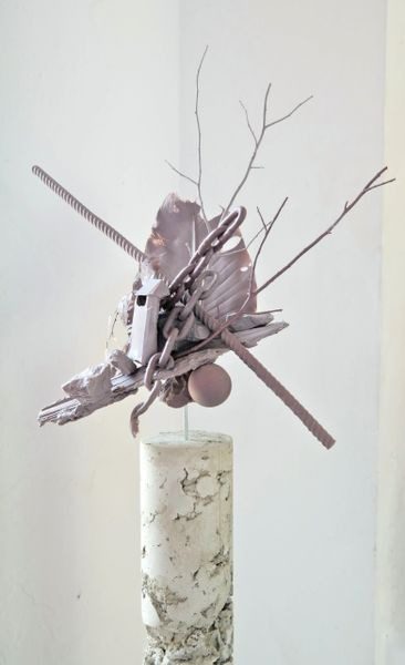 A sculpture of branches and sticks on top of a marble base.