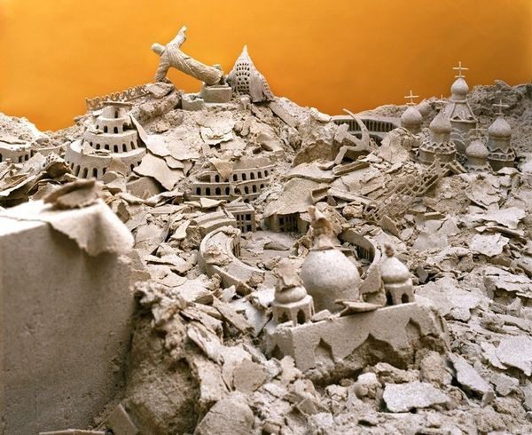 A pile of rubble with a yellow wall in the background.