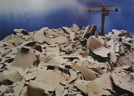 A pile of rubble with a crane in the background.