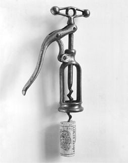 A black and white photo of an old fashioned hand pump.