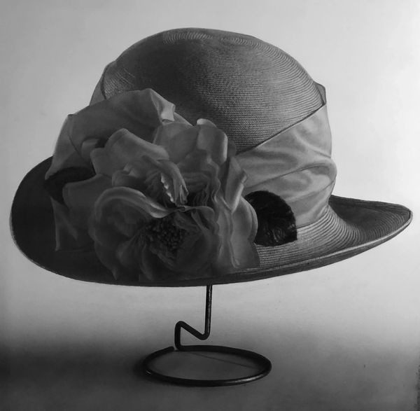 A hat on a stand with a flower in it.