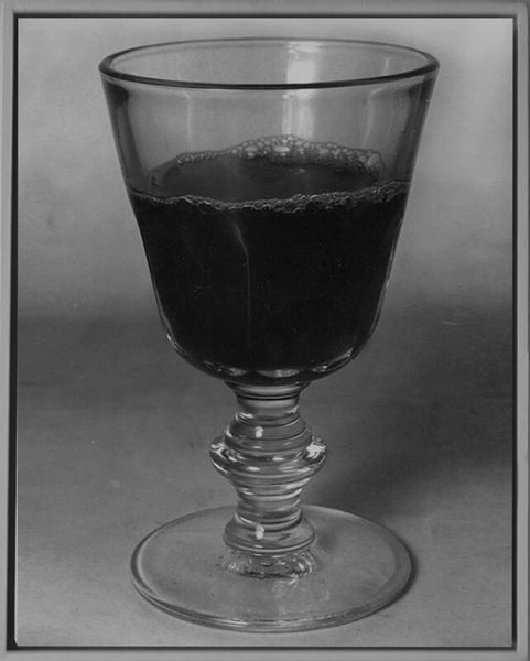 A glass of wine is shown in black and white.