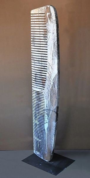 A comb is wrapped in duct tape and placed on the wall.