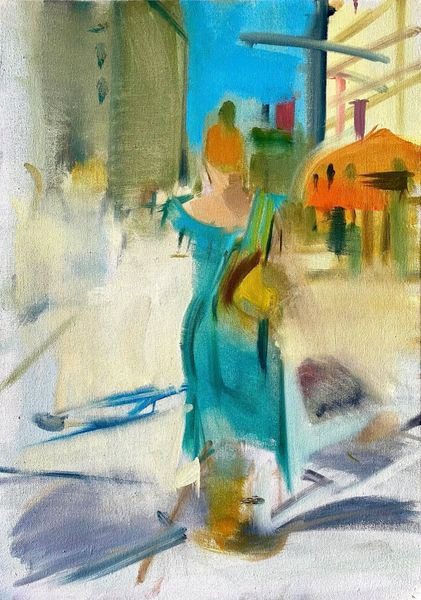 A woman in blue dress walking down the street.