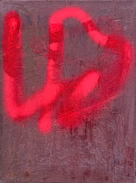 A red spray paint on the side of a building.