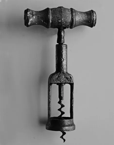 A black and white photo of an old corkscrew.