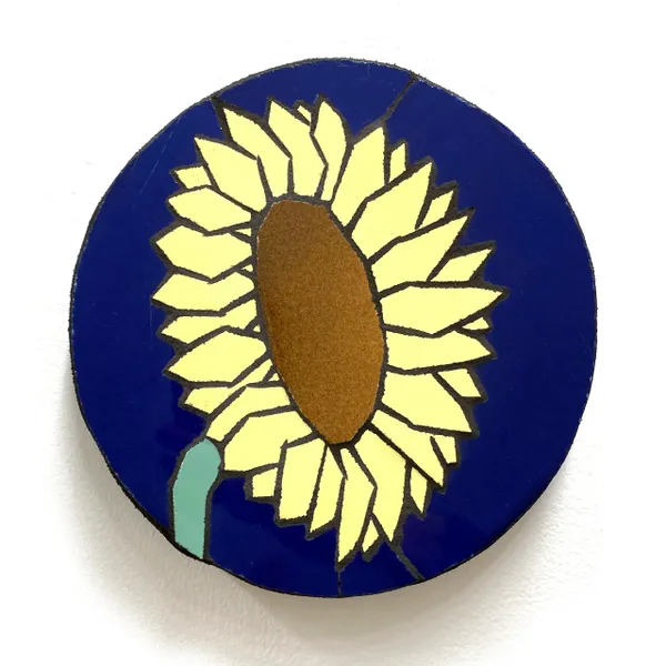 A blue button with a yellow sunflower on it.