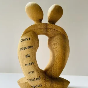 A wooden sculpture of two people with words on them.