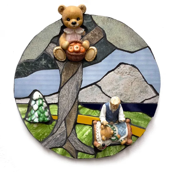 A stained glass picture of a bear and a tree.