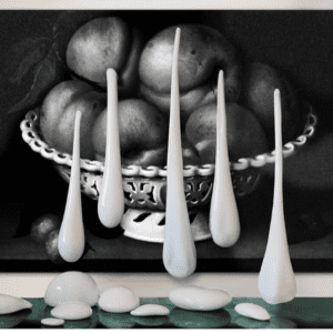 A bowl of fruit with white spoons in front.